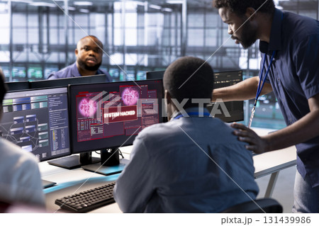 Team of computer scientists in server hub working together to protect equipment from hacker. IT coworkers in data center facility collaborating to fix security breach alert 131439986