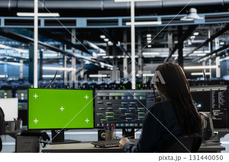 Engineer in data center using green screen computer to check equipment performance upgrading infrastructure. Worker doing maintenance on supercomputers in servers room using mockup PC 131440050