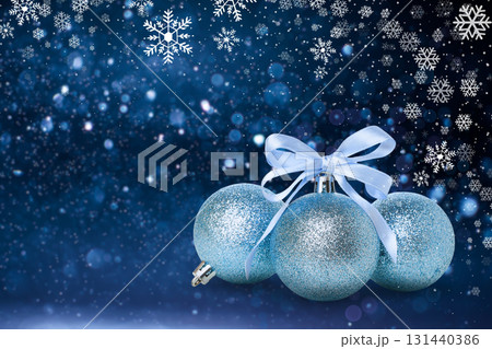 Shimmering blue ornaments sit elegantly against a snowy backdrop 131440386