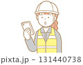スマートフォンの画面を見る作業着にヘルメット安全ベストの赤い髪の女性のイラスト 131440738