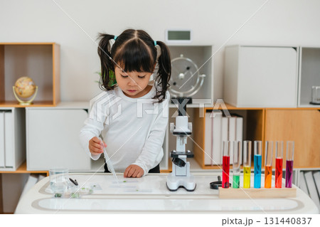 toddler girl scientist using pipette dropping of liquid being placed on glass slide, preparing specimen for science microscope toddler girl scientist using pipette dropping of liquid being placed on glass slide, preparing specimen for science microscope 131440837