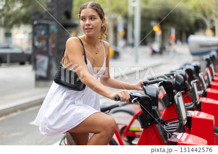 Young woman renting a bicycle 131442576