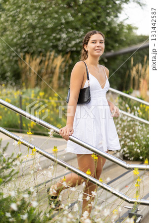 Young woman walks around the city and climbs the stairs Young woman walks around the city and climbs the stairs 131442587