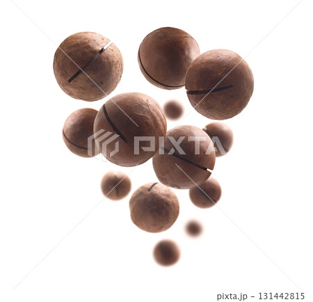Unpeeled macadamia nuts levitate on a white background 131442815