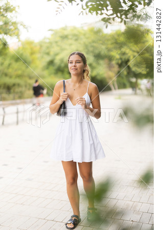 Young woman walking in city park Young woman walking in city park 131442827