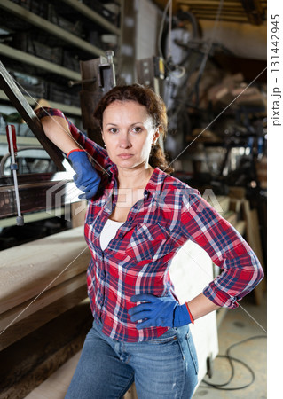 Adult woman posing in oak workshop 131442945