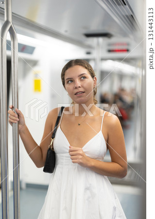 Calm young girl standing on wagon travelling by subway 131443113