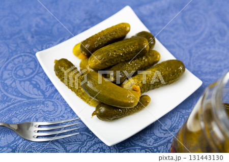 Pickled cucumbers on white plate, homemade preserves Pickled cucumbers on white plate, homemade preserves 131443130