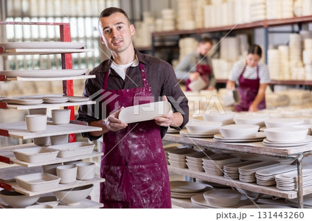 Young man posing with ceramic blanks Young man posing with ceramic blanks 131443260