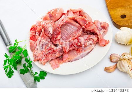 Chopped rabbit with garlic and spices on white plate with knife Chopped rabbit with garlic and spices on white plate with knife 131443378