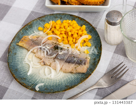 Pickled herring slices with canned corn kernels and onions Pickled herring slices with canned corn kernels and onions 131443387