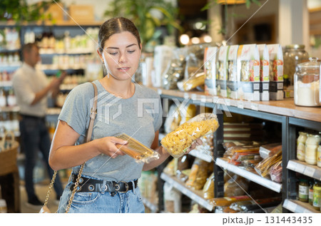 Young girl purchaser buying pasta in grocery store 131443435