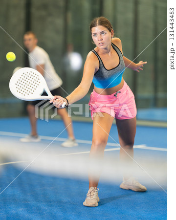 Young woman and man playing doubles tennis Young woman and man playing doubles tennis 131443483