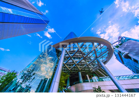 日本の東京都市景観　高輪ゲートウェイ駅前の高輪ゲートウェイシティなどを望む。上空に航空機（G連続） 131444167