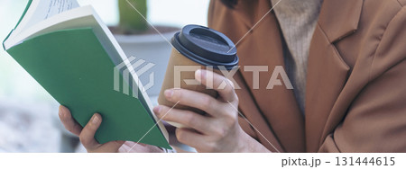 Banner hands of woman sitting office desk holding sweet coffee cup relax and enjoy with happy time. Panorama Hot coffee mug. Woman holding coffee cup relaxing after work at office in cafe copy space Banner hands of woman sitting office desk holding sweet coffee cup relax and enjoy with happy time. Panorama Hot coffee mug. Woman holding coffee cup relaxing after work at office in cafe copy space 131444615