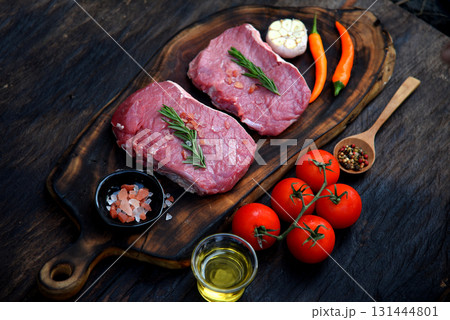 Top view raw beef tender meat steak grill pork barbeque on wooden board. Steak western cuisine ingredient fresh herb meat pepper olive oil garlic chilli tomato salt rosemary on wood plate outdoor. 131444801