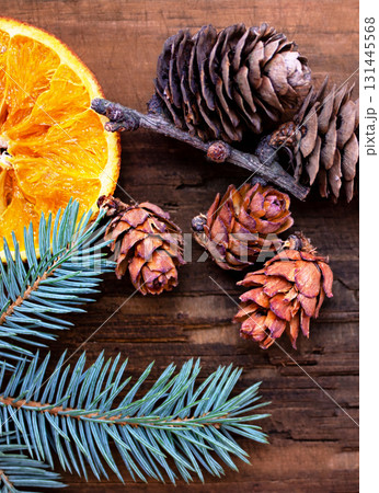 Christmas photo of a fir branch with dried oranges and fir cones 131445568