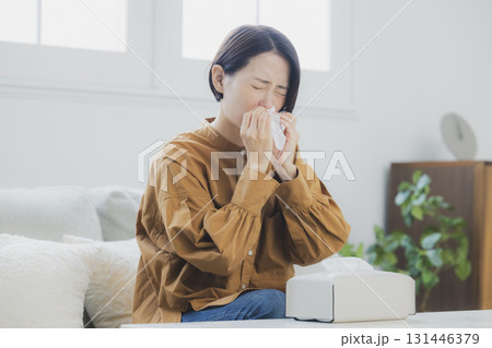 風邪をひいて鼻をかむ女性 131446379