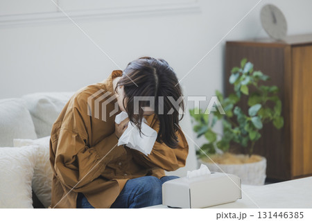 風邪をひいて鼻をかむ女性 131446385