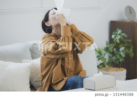 風邪をひいて鼻をかむ女性 131446386