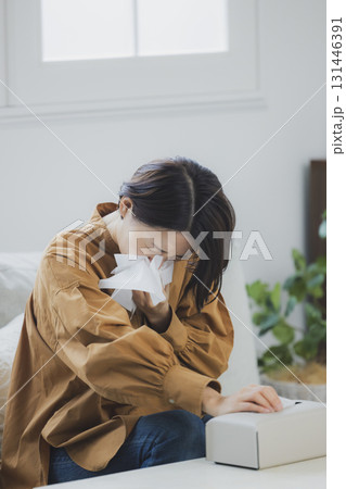 風邪をひいて鼻をかむ女性 131446391