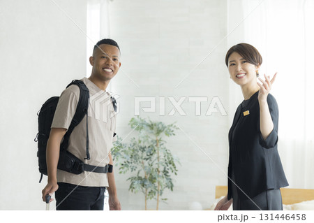 外国人の男性に説明をするホテルマンの女性 外国人の男性に説明をするホテルマンの女性 131446458