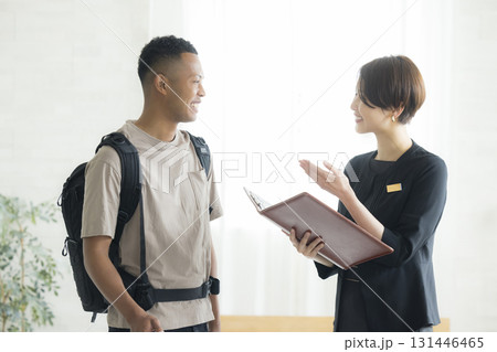 外国人の男性に説明をするホテルマンの女性 131446465