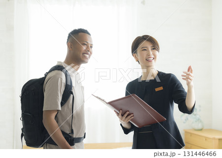 外国人の男性に説明をするホテルマンの女性 131446466