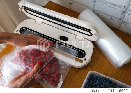Vacuum sealer of strawberries, honeysuckle in bag, packaging for long-term storage . Vacuum packing machine Vacuum sealer of strawberries, honeysuckle in bag, packaging for long-term storage . Vacuum packing machine 131446495