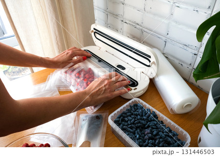 Vacuum sealer of strawberries, honeysuckle in bag, packaging for long-term storage . Vacuum packing machine Vacuum sealer of strawberries, honeysuckle in bag, packaging for long-term storage . Vacuum packing machine 131446503