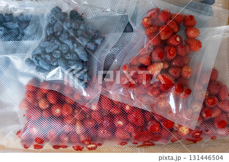 Vacuum sealer of strawberries, honeysuckle in bag, packaging for long-term storage . Vacuum packing machine Vacuum sealer of strawberries, honeysuckle in bag, packaging for long-term storage . Vacuum packing machine 131446504