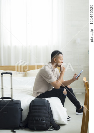 ホテルの客室でスマホを見る外国人の男性 131446529