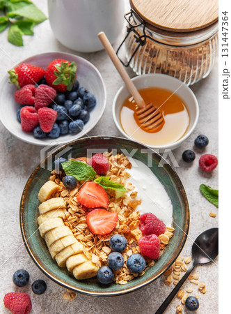 Delicious granola with yogurt, banana, and berries creating a nutritious breakfast Delicious granola with yogurt, banana, and berries creating a nutritious breakfast 131447364