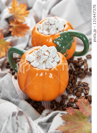 Pumpkin mugs with marshmallows, coffee beans, autumn leaves Pumpkin mugs with marshmallows, coffee beans, autumn leaves 131447376