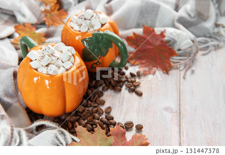 Pumpkin mugs with marshmallows, coffee beans, autumn leaves Pumpkin mugs with marshmallows, coffee beans, autumn leaves 131447378