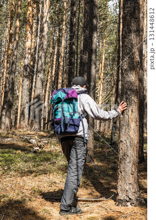 elderly hiker resting while exploring forested area on sunny day surrounded by tall trees. closeup. 131448612