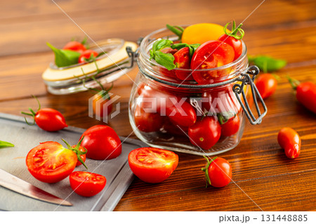 Rustic kitchen scene with tomatoes basil and jar Rustic kitchen scene with tomatoes basil and jar 131448885