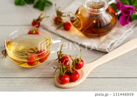ripe red rose hips for tea on a wooden table 131448939