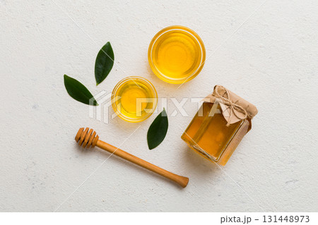 Honey jar with wooden honey dipper on white background top view with copy space. Delicious honey bottle Honey jar with wooden honey dipper on white background top view with copy space. Delicious honey bottle 131448973