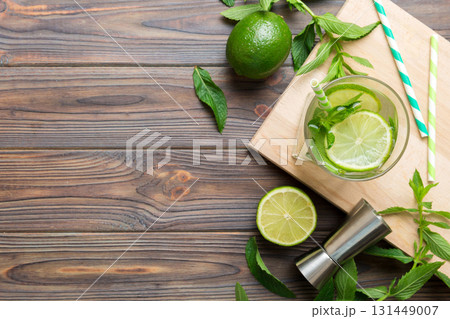 Caipirinha, Mojito cocktail, vodka or soda drink with lime, mint and straw on table background. Refreshing beverage with mint and lime in glass top view flat lay Caipirinha, Mojito cocktail, vodka or soda drink with lime, mint and straw on table background. Refreshing beverage with mint and lime in glass top view flat lay 131449007