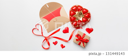 Envelope on colored background for Valentine Day with gift box and chocolate. Heart shaped with gift box of chocolates top view with copy space Envelope on colored background for Valentine Day with gift box and chocolate. Heart shaped with gift box of chocolates top view with copy space 131449143