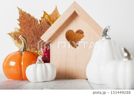 Minimal Wooden House with Heart and Pumpkins. Cozy Autumn Decor Minimal Wooden House with Heart and Pumpkins. Cozy Autumn Decor 131449288