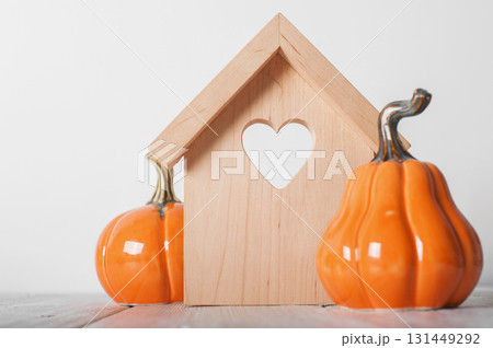 Minimal Wooden House with Heart and Pumpkins. Cozy Autumn Decor Minimal Wooden House with Heart and Pumpkins. Cozy Autumn Decor 131449292