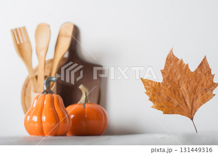Autumn Kitchen Decor with Wooden Utensils and Ceramic Pumpkins 131449316