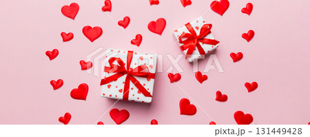 Valentine day composition Background: red gift box with bow and heart. Christmas present. View from above. Holday greeting card Valentine day composition Background: red gift box with bow and heart. Christmas present. View from above. Holday greeting card 131449428