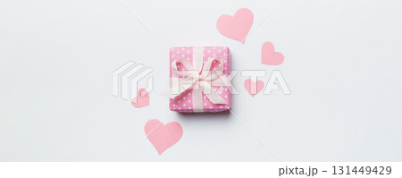 Valentine day composition Background: red gift box with bow and heart. Christmas present. View from above. Holday greeting card Valentine day composition Background: red gift box with bow and heart. Christmas present. View from above. Holday greeting card 131449429