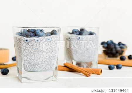 Healthy breakfast or morning with chia seeds vanilla pudding and blueberry berries on table background, vegetarian food, diet and health concept. Chia pudding with coconut milk and blueberry Healthy breakfast or morning with chia seeds vanilla pudding and blueberry berries on table background, vegetarian food, diet and health concept. Chia pudding with coconut milk and blueberry 131449464