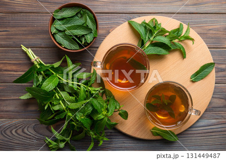 Cup of mint tea on table background. Green tea with fresh mint top view with copy space Cup of mint tea on table background. Green tea with fresh mint top view with copy space 131449487
