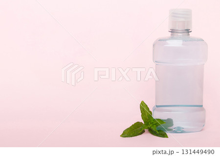 Mouthwash and fresh mint on colored background, top view with copy space for text Mouthwash and fresh mint on colored background, top view with copy space for text 131449490