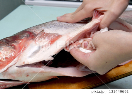 Cooking silver carp. cleaning ribs and blotting its insides with a napkin 131449691